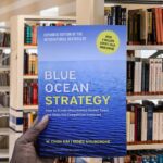 Cover of Blue Ocean Strategy by W. Chan Kim and Renée Mauborgne featuring a calm blue sea and a minimalist design.