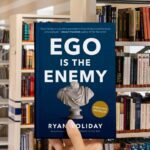 Cover of the book Ego Is the Enemy by Ryan Holiday featuring bold white text on a dark blue background with a Roman bust.