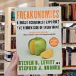 Book cover of Freakonomics by Steven D. Levitt and Stephen J. Dubner, featuring a green apple with an orange interior.