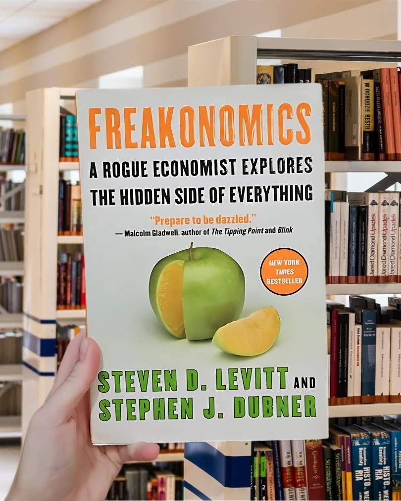 Book cover of Freakonomics by Steven D. Levitt and Stephen J. Dubner, featuring a green apple with an orange interior.