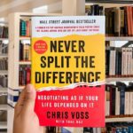 Cover of the book "Never Split the Difference" by Chris Voss, featuring bold red and yellow colors with large, distressed black title text.
