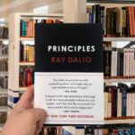 Cover of the book “Principles” by Ray Dalio, featuring a black background with bold red and white typography.