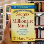 Cover of Secrets of the Millionaire Mind by T. Harv Eker, featuring a bold yellow and blue design with the subtitle: "Mastering the Inner Game of Wealth."