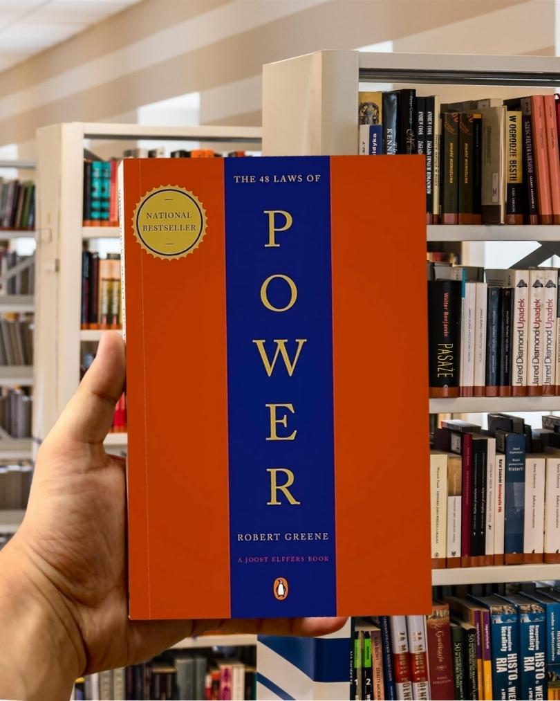 Cover of The 48 Laws of Power by Robert Greene, featuring a bold red and blue vertical split design with gold serif text.